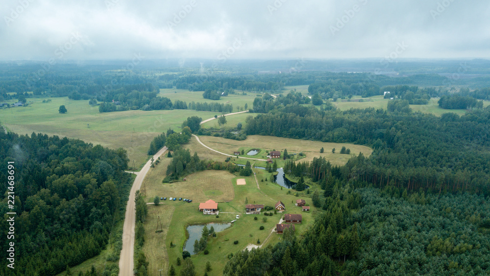 drone image. aerial view of rural area with fields and forests under dramatic storm clouds forming