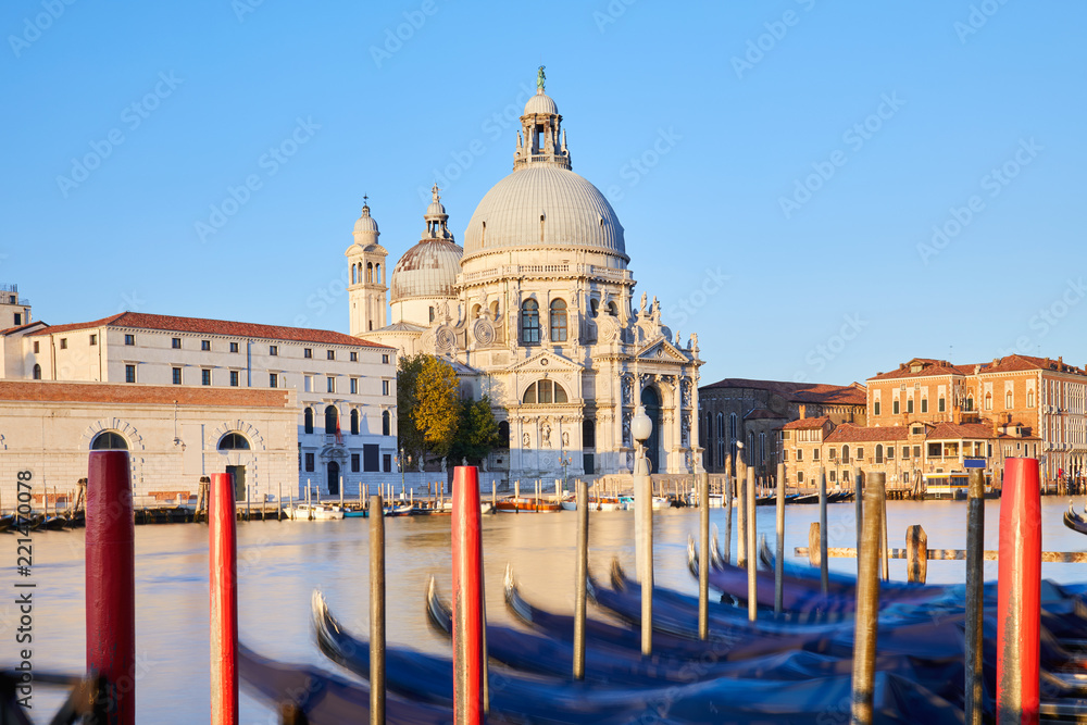 Venice, Saint Mary of Health basilica and moored gondolas in a sunny morning, nobody