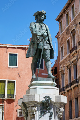 Playwright Carlo Goldoni statue with pedestal by Antonio Dal Zotto (1841-1918) in Venice, clear blue sky in Italy