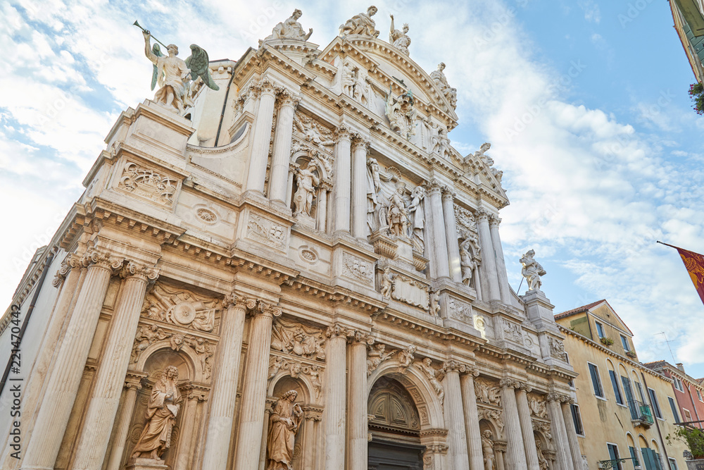 Santa Maria del Giglio, low angle view of baroque church facade in a sunny day, white clouds in Italy