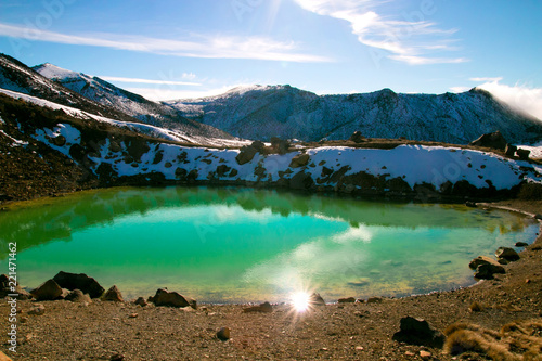 Beautiful blue turquoise lake known like Emerald lake in Tongariro National Park New Zealand North Island, alpine crossing, active volcanic terrain and unique lake during sunny day, snow on mountains
