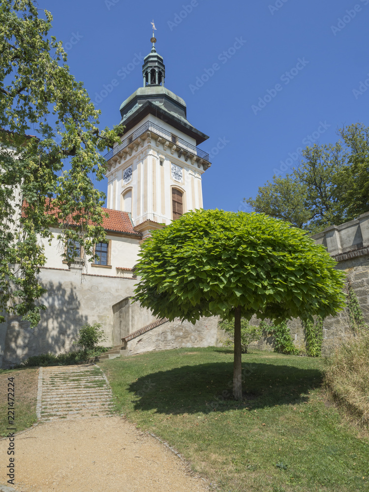 old town hall tower in castle park Benatky nad Jizerou with footpath, stair, green trees, sunny summer day, blue sky background