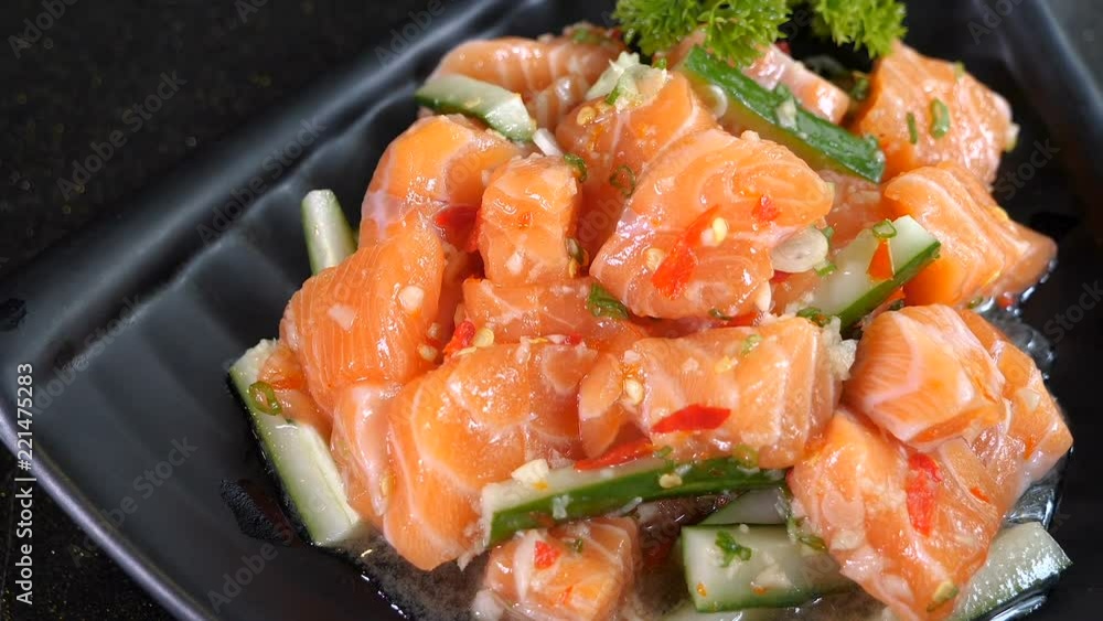 Salmon sashimi spicy salad on black dish in the restaurant (Japanese food) Salmon sashimi spicy salad on black dish in the restaurant (Japanese food)