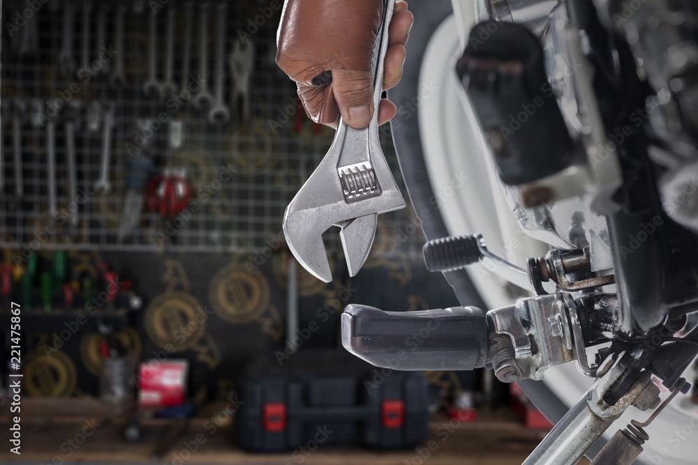 Fototapeta premium Przycięty widok mechanika za pomocą klucza na motocyklu