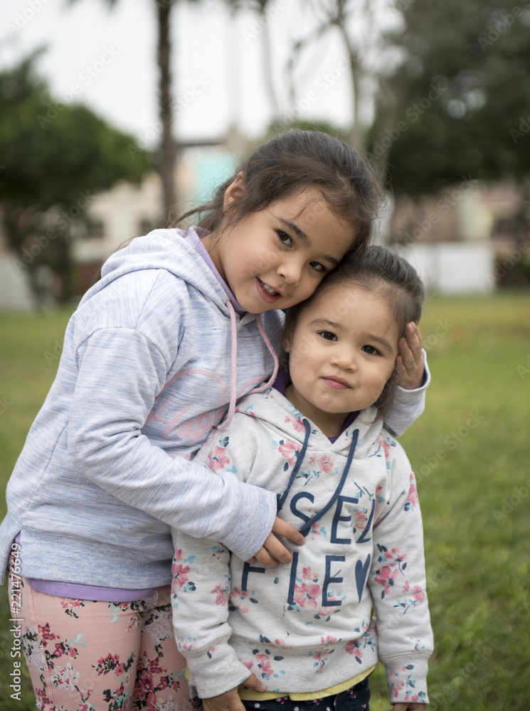 Happy funny girl twins sisters hugging and laughing Happy funny girl twins sisters hugging and laughing