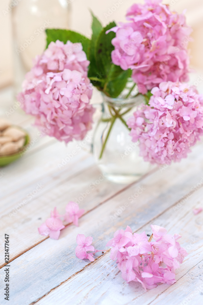 Bouquet of pink flowers in a glass vase on a light background