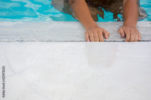 Close Up of Hands of a Child at the Poolside on Blue Reflections