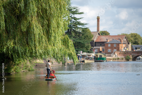 stratford upon Avon Warwickshire England UK August 23rd punt under a willow tree with beautiful buildings and bridge in the background during English summer