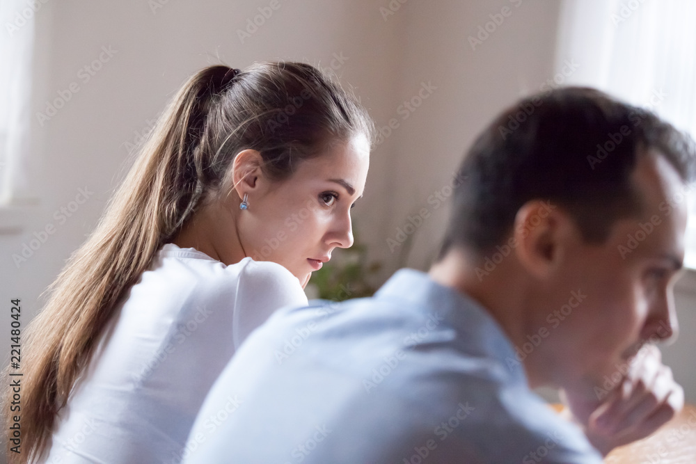 Back view of offended woman looking at stubborn lover refusing reconcile after fight, mad millennial couple not talking after quarrel, man avoid looking or speaking to female after family conflict Back view of offended woman looking at stubborn lover refusing reconcile after fight, mad millennial couple not talking after quarrel, man avoid looking or speaking to female after family conflict