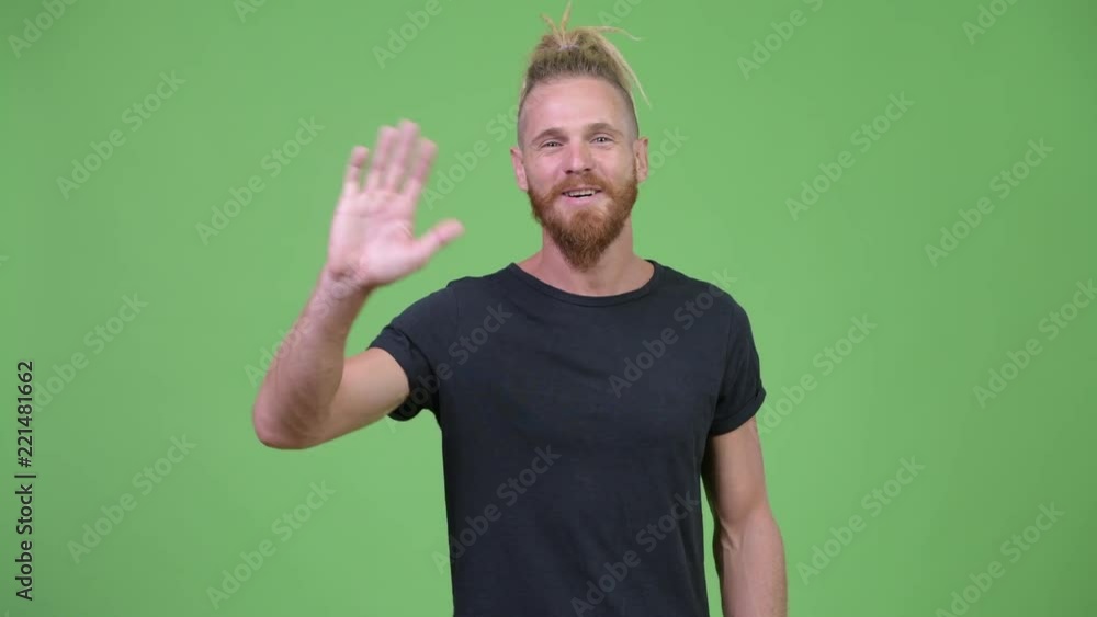 Handsome bearded man with dreadlocks smiling while greeting Handsome bearded man with dreadlocks smiling while greeting