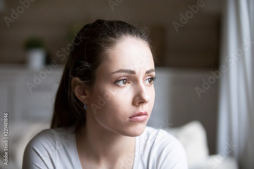 Sad young woman looking in distance thinking about relationships problems, upset hurt girl view from window sorrow about breakup with boyfriend, disappointed female feeling blue having troubles