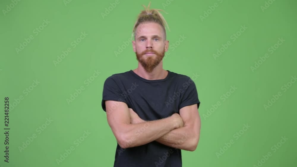 Handsome bearded man with dreadlocks crossing arms Handsome bearded man with dreadlocks crossing arms