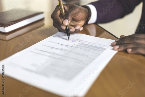 African american man signing contract, black man hand putting signature on official document, biracial clients customers couple make purchase or sign prenuptial agreement concept. clouse up photo