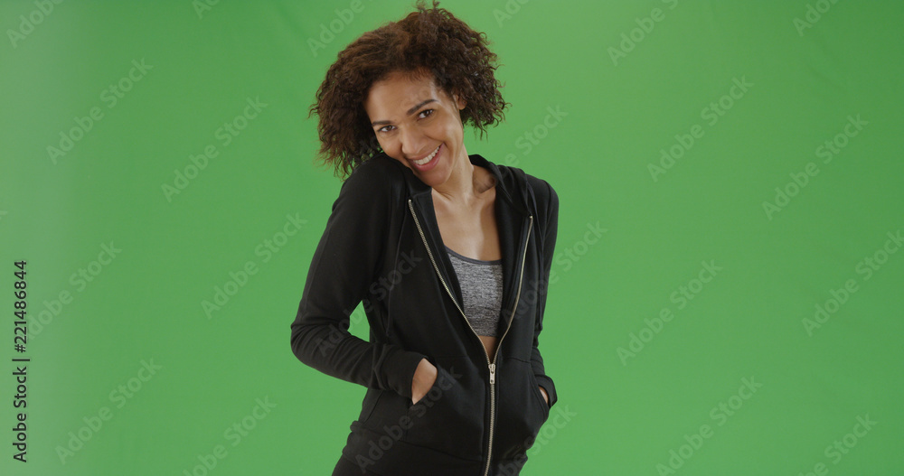 Black millennial girl smiles at the camera in her gym clothes on green screen Black millennial girl smiles at the camera in her gym clothes on green screen