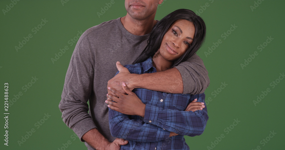 Black woman looking at camera while boyfriend embraces her on green screen Black woman looking at camera while boyfriend embraces her on green screen