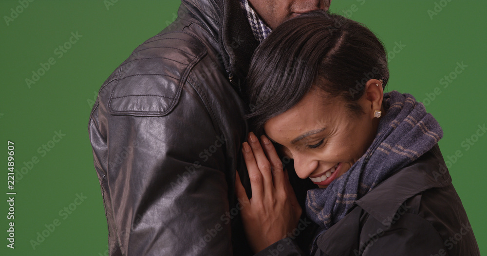 Young black woman embracing her boyfriend green screen