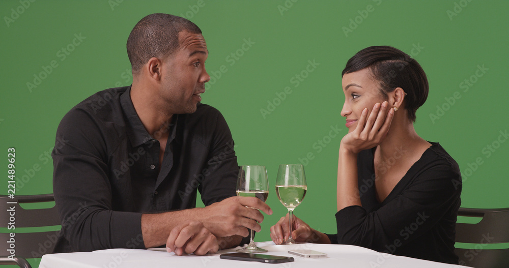 A black couple chatting while on a date on green screen