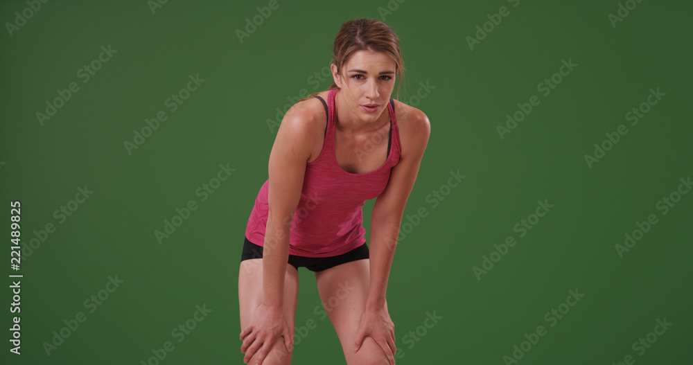 Woman in her 20s taking a quick break from workout on green screen Woman in her 20s taking a quick break from workout on green screen