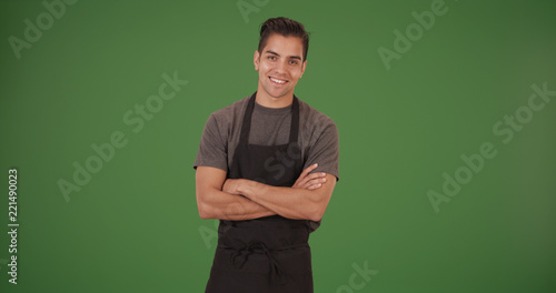 Happy handsome young Latino restaurant employee on green screen photo