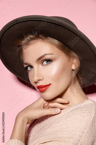 Beautiful model with fresh clean skin and red lips on pink background. Skincare and makeup concept.