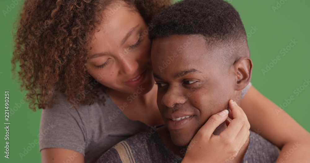 Fototapeta premium Loving black girlfriend embracing her boyfriend on green screen