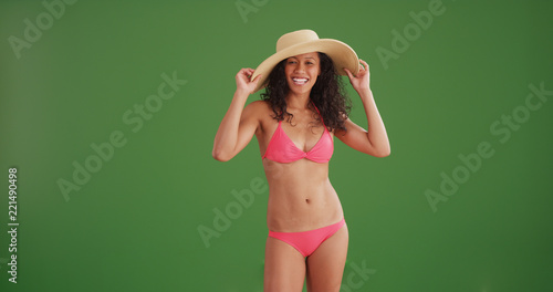 Mixed race woman smiling wearing a bikini and sunhat on green screen