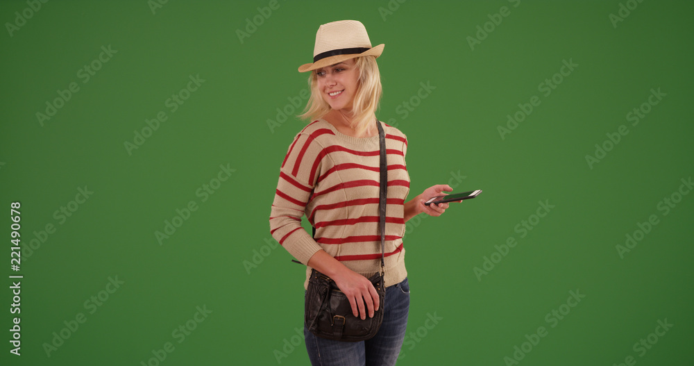 Stylish hipster woman with smartphone standing on green screen Stylish hipster woman with smartphone standing on green screen