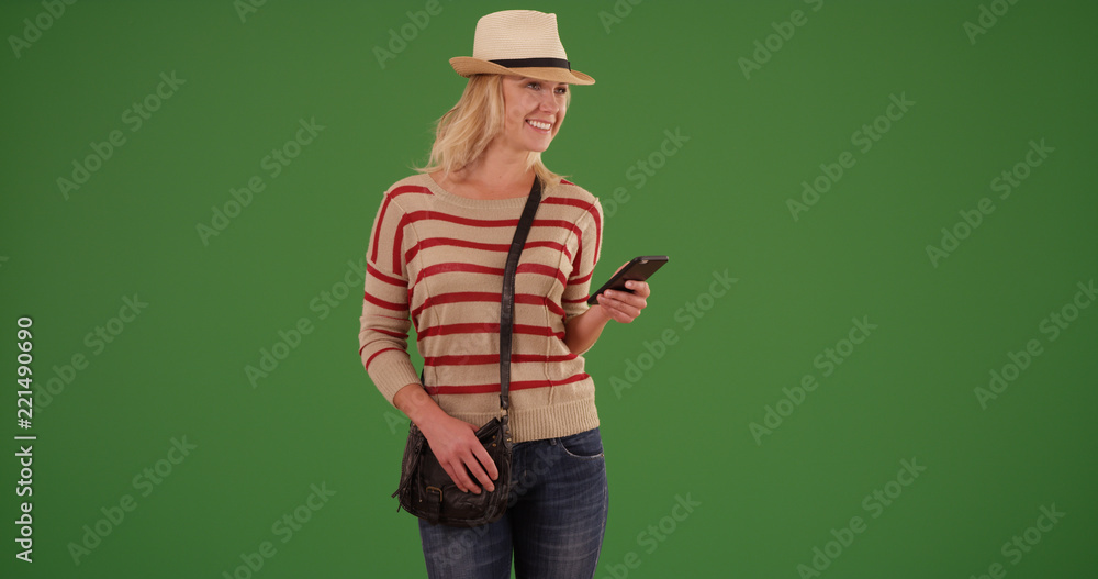 Happy female hipster with smartphone looking happy on green screen Happy female hipster with smartphone looking happy on green screen