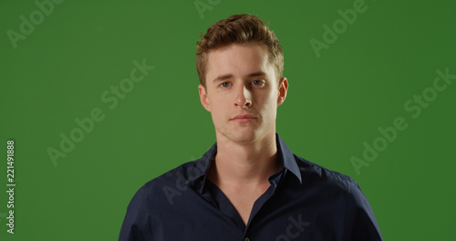 Canvas-taulu Handsome young Caucasian man looking at camera on green screen