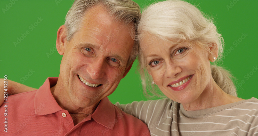 Closeup of happy senior couple smiling at camera on green screen Closeup of happy senior couple smiling at camera on green screen