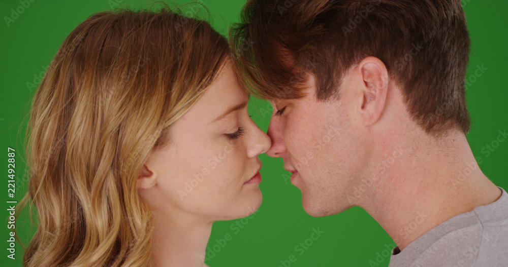 Side profile of young Caucasian couple about to kiss on green screen Side profile of young Caucasian couple about to kiss on green screen
