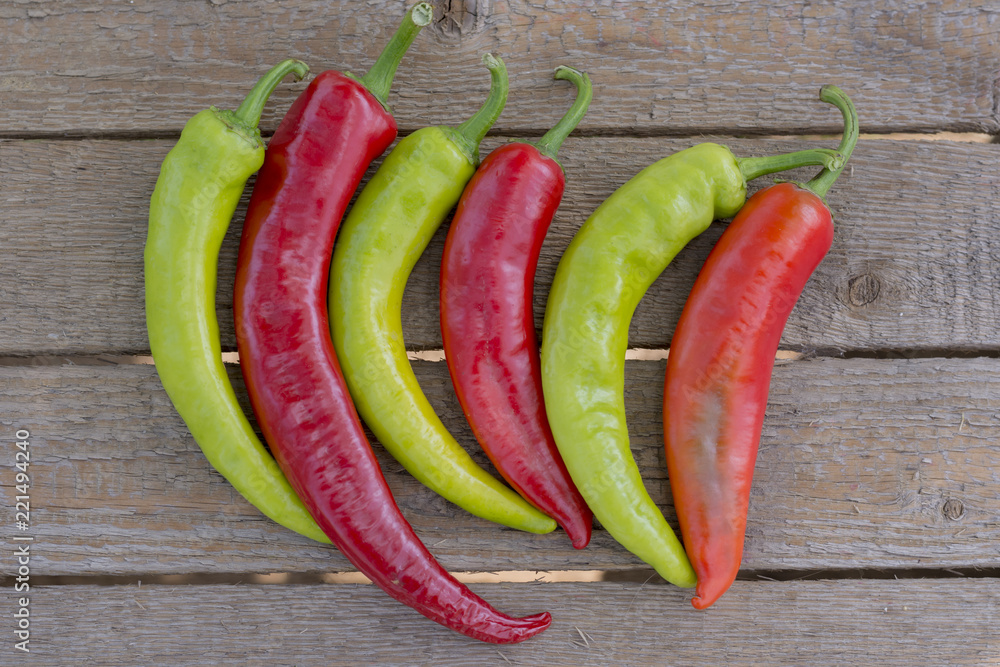 Red and green bitter, hot pepper, on a wooden background, copy space, flatly,