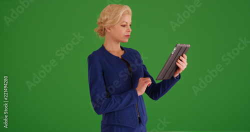 Portrait of Caucasian businesswoman using pad device on green screen