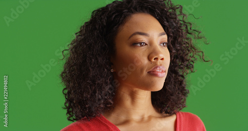 Attractive African American girl looking offscreen thoughtfully on green screen photo