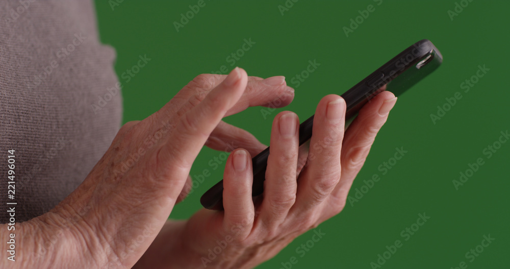 Close up shot of elderly female's hands using smartphone on green screen Close up shot of elderly female's hands using smartphone on green screen