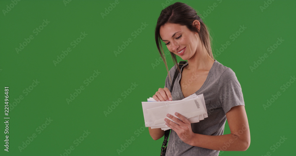 Smiling Caucasian woman looking through letters she received on green screen Smiling Caucasian woman looking through letters she received on green screen