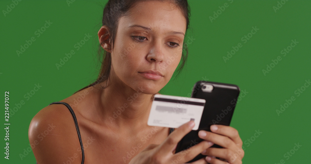 Woman making online payment with credit card using smartphone on green screen Woman making online payment with credit card using smartphone on green screen