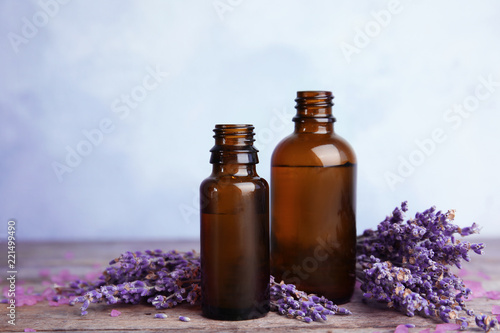 Fototapeta Naklejka Na Ścianę i Meble -  Bottles with aromatic lavender oil on wooden table