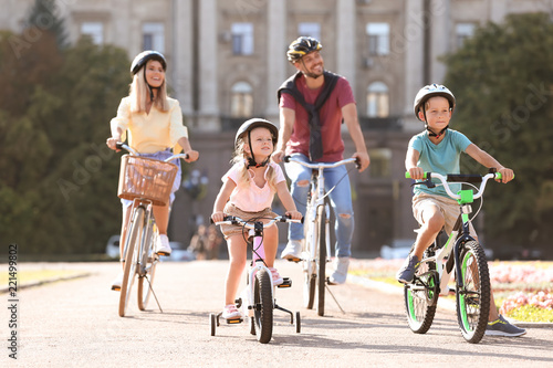 Happy family riding bicycles outdoors on summer day