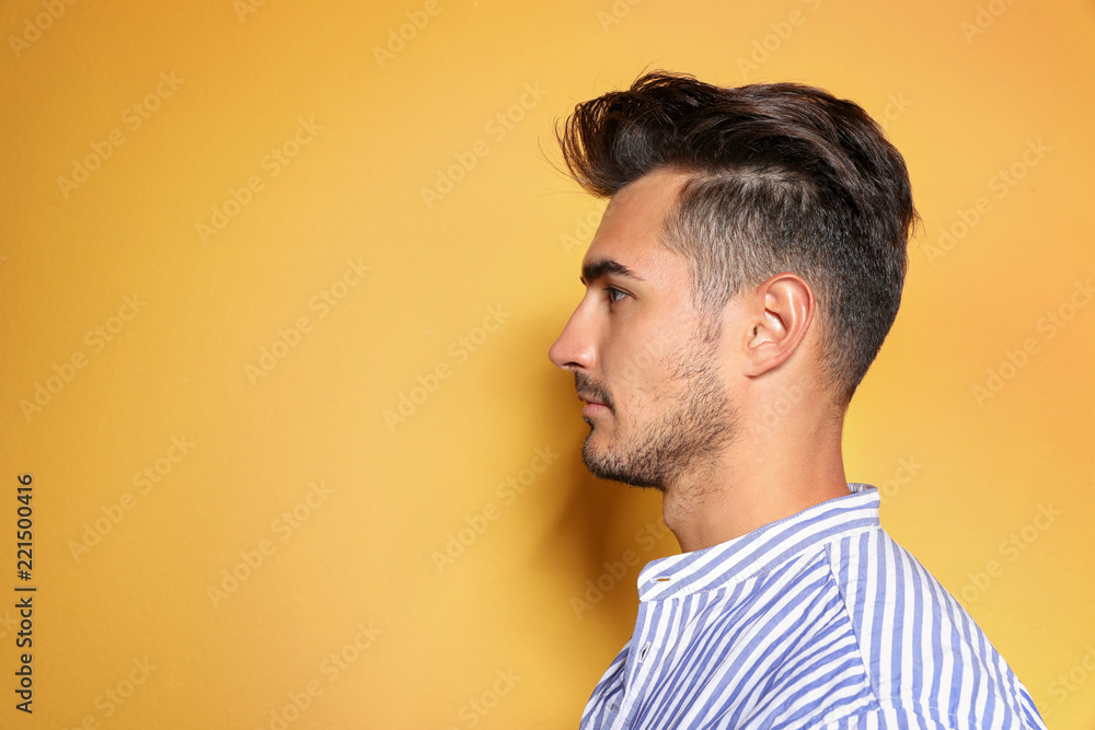 Young man with trendy hairstyle posing on color background Young man with trendy hairstyle posing on color background