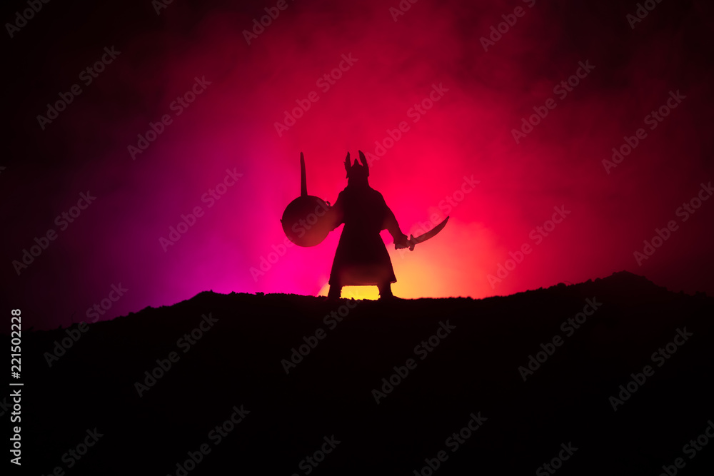 Fighter with a sword silhouette a sky. Medieval knight with sword. Selective focus