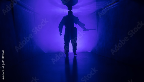 Creepy silhouette in the dark abandoned building. Horror about maniac concept or Dark corridor with cabinet doors and lights with silhouette of spooky horror person