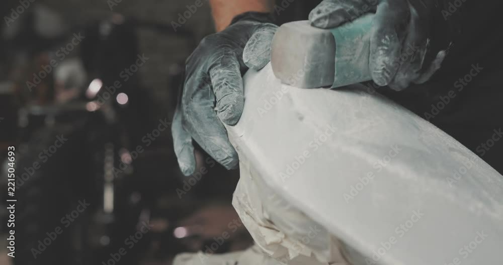 Guy polishing metal gas tank with sandpaper. Auto mechanic assembles