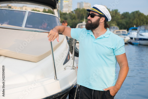 A man with a beard leaned on his yacht