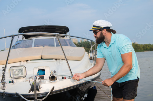 A man with a beard tries to moor his yacht