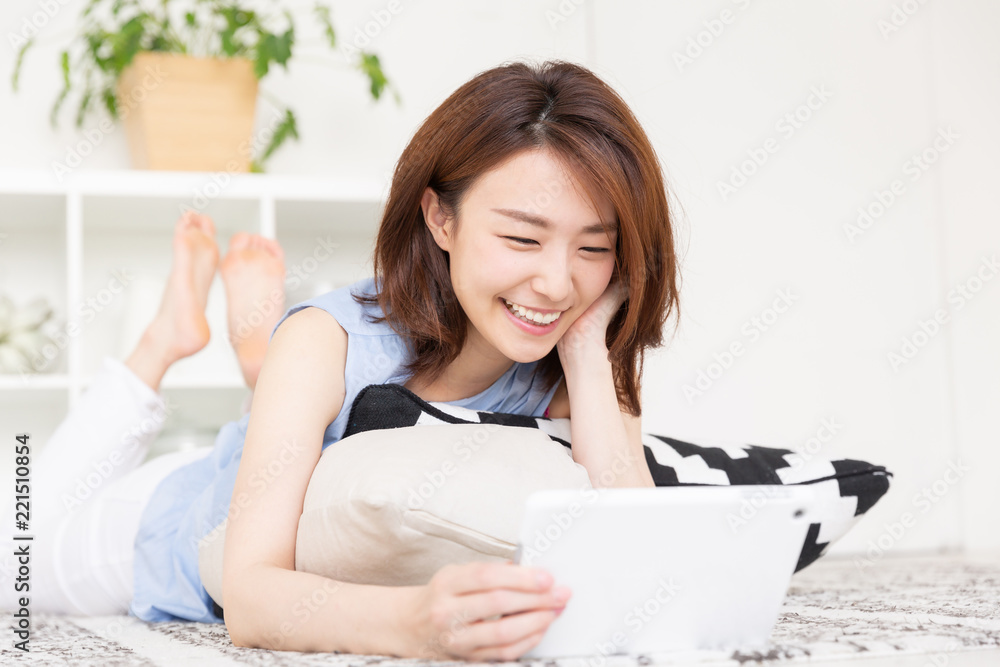 部屋でタブレットを見る女性 部屋でタブレットを見る女性
