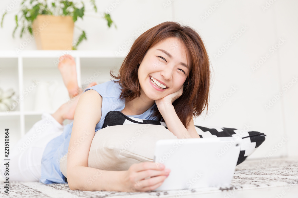 部屋でタブレットを見る女性 部屋でタブレットを見る女性