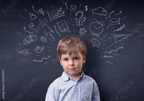 Smart little kid in front of a drawn up blackboard ruminate