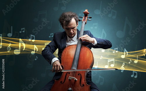 Young male musician playing on his cello with musical notes around photo