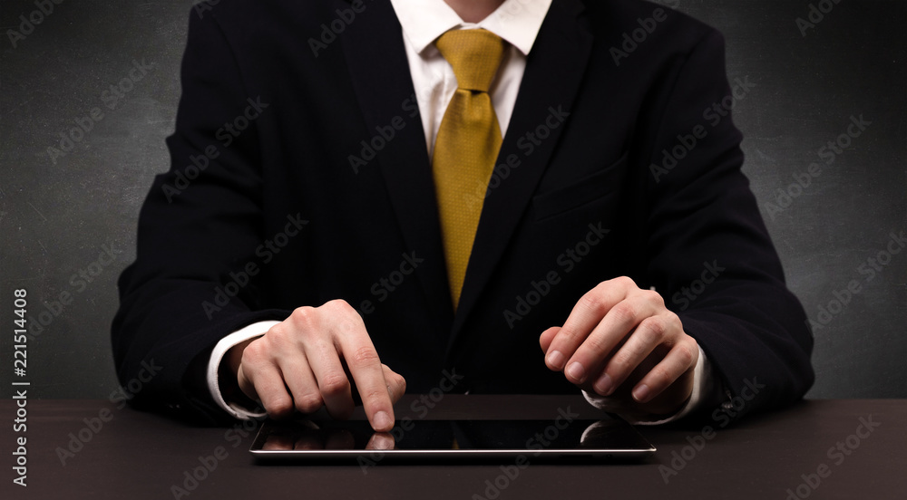 Businessman in suit typing with dark background Businessman in suit typing with dark background